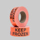 A roll of orange moving labels with the text 'KEEP FROZEN' printed in black.